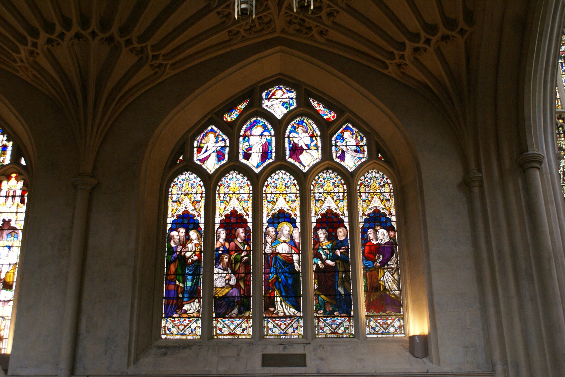 A 5-panel stained-glass window shows Jesus surrounded by his apostles