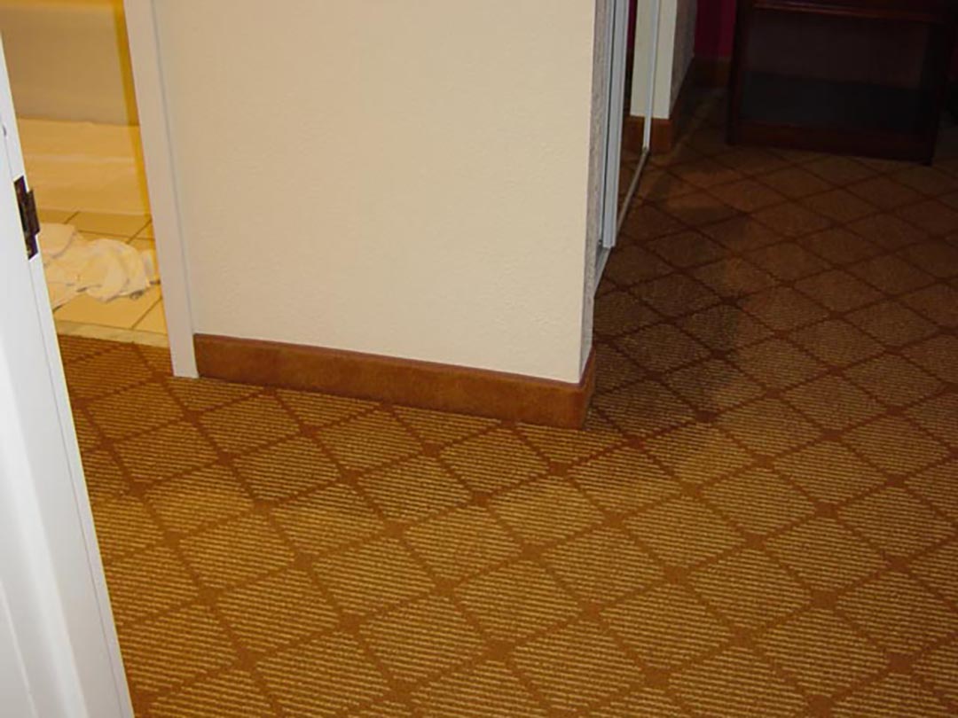 Wet carpet around the door to a hotel restroom