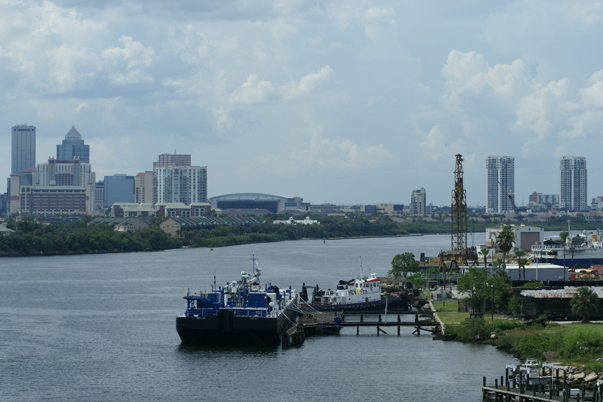 City skyline above trees and a channel of water