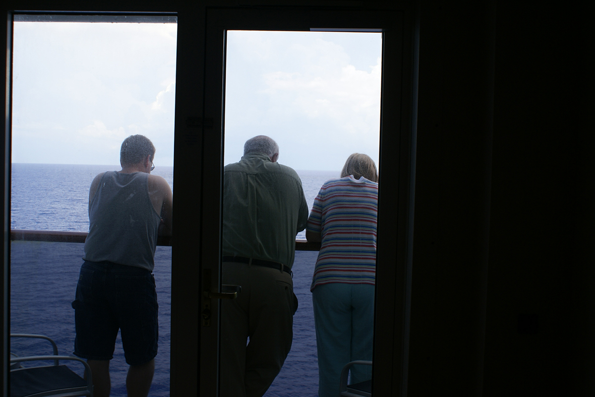 James, Gary, and Surella stand at the railing of a balcony