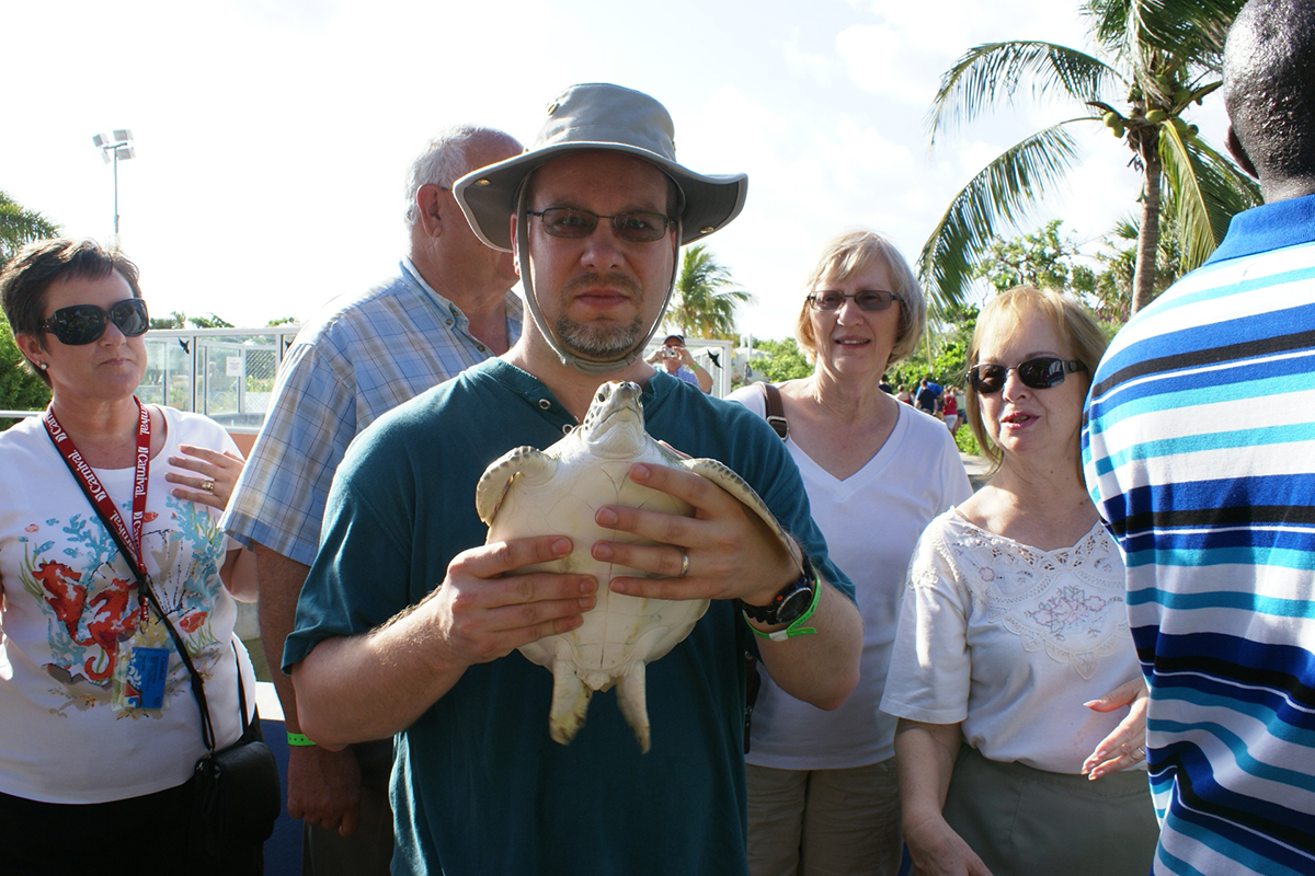 James holds a sea turtle about the size of dinner plate