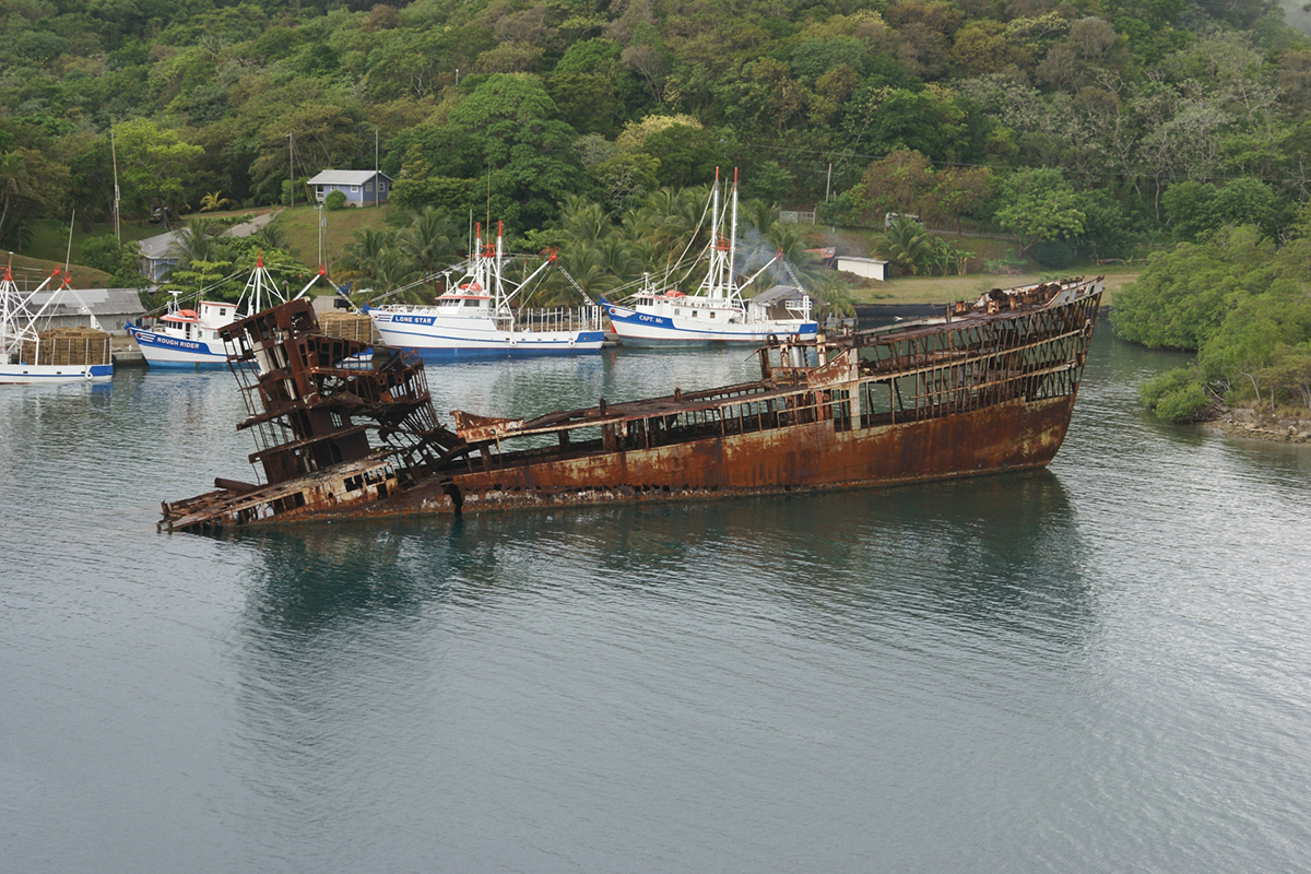 A rusting shipwreck sticks out of the water