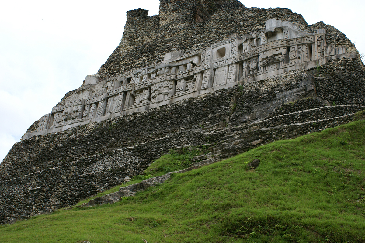 A band of elaborate stone carvings amongst the rough stone of the main temple