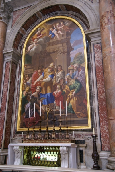 A detailed and vibrant painting is inset in a large arch above the crypt with a mummified human in papal robes visible through a glass side