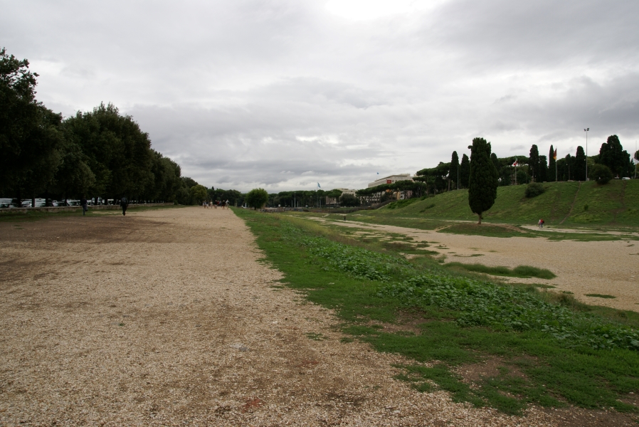 Long gravel paths 20-feet wide run in a loop around a raised green strip with trees at either end with slopes running along the outside