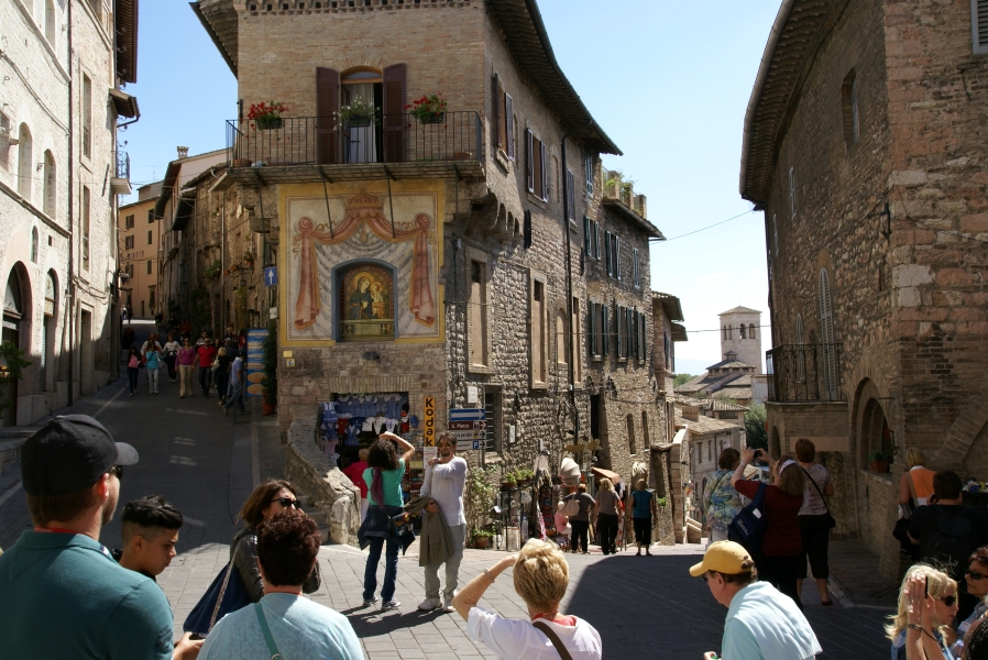 Tan and brown stone buildings stand three and more stories tall on hilly streets only about 15-feet wide
