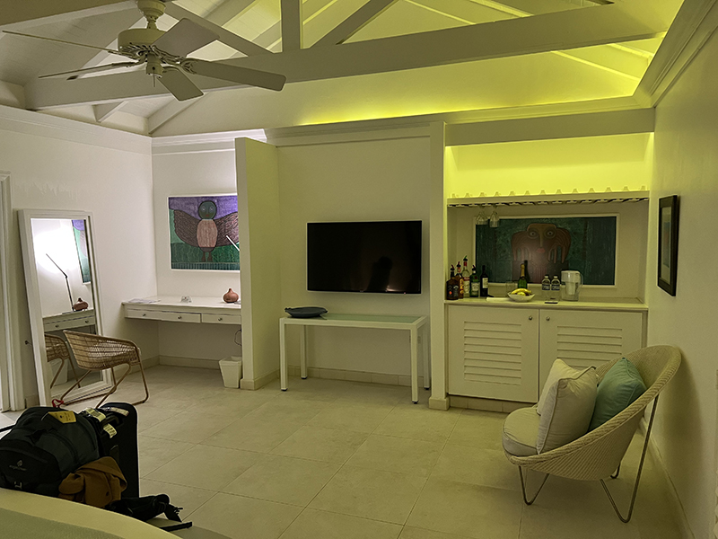 Wall of hotel room with desk, TV, and bar area
