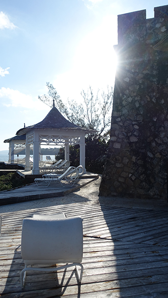 Lounge chairs line the boardwalk near a stone tower