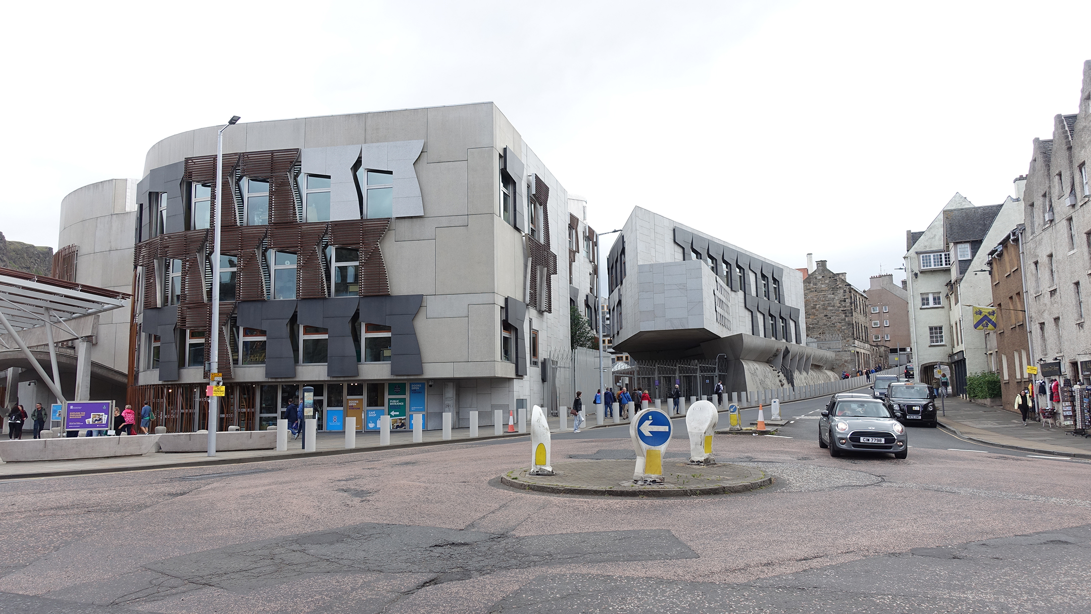 Mmodern building across street from historic stone structures