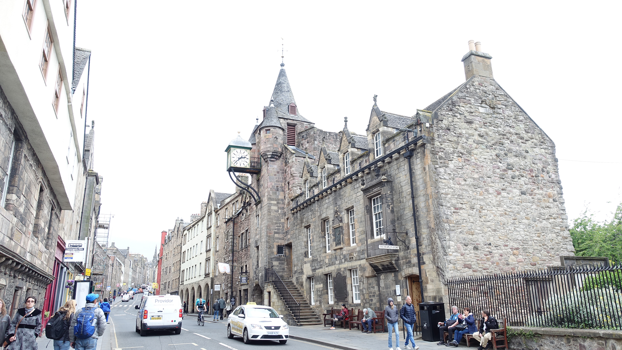 Three story stone buildings on either side of a two lane road