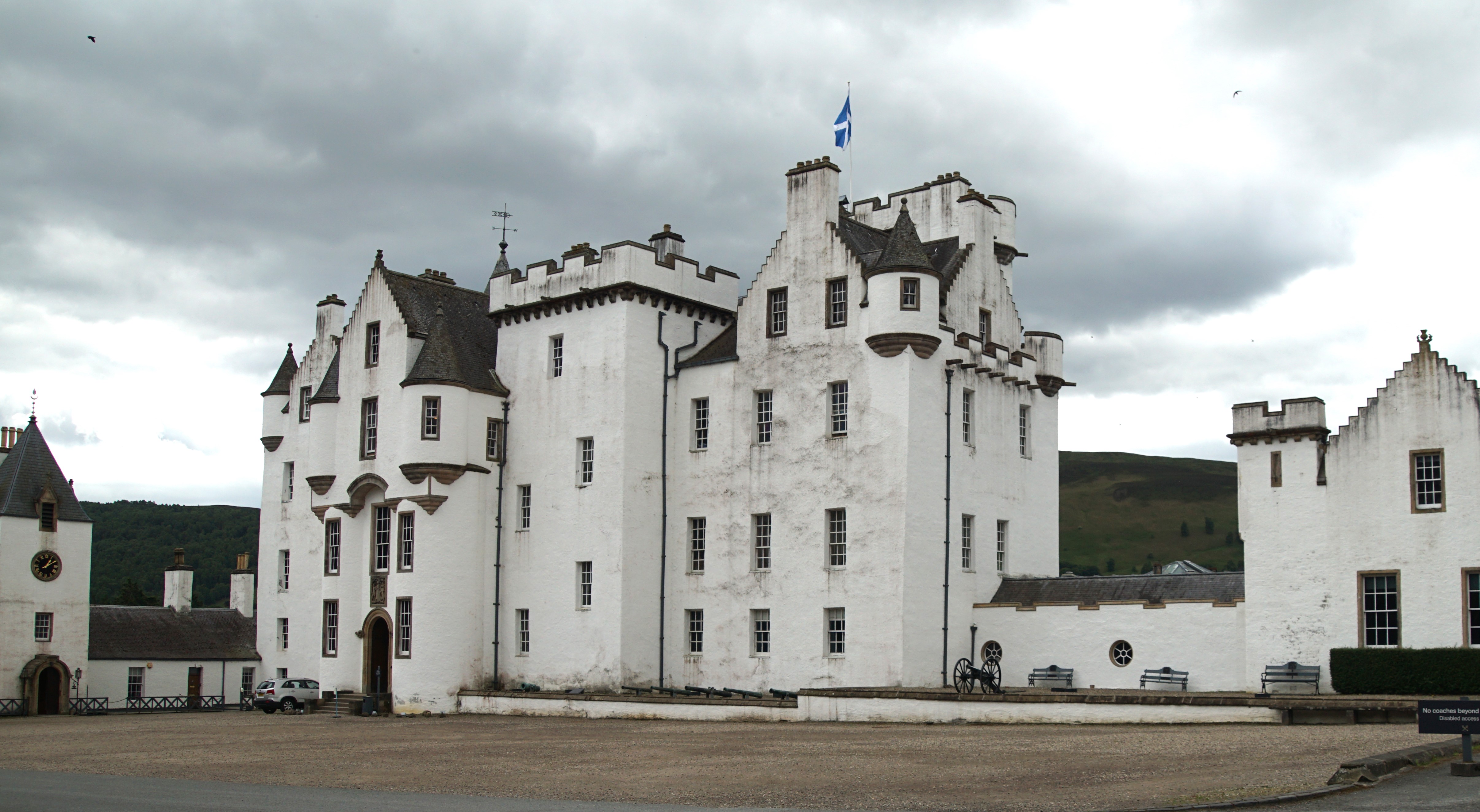 White walled castle in front of green hills