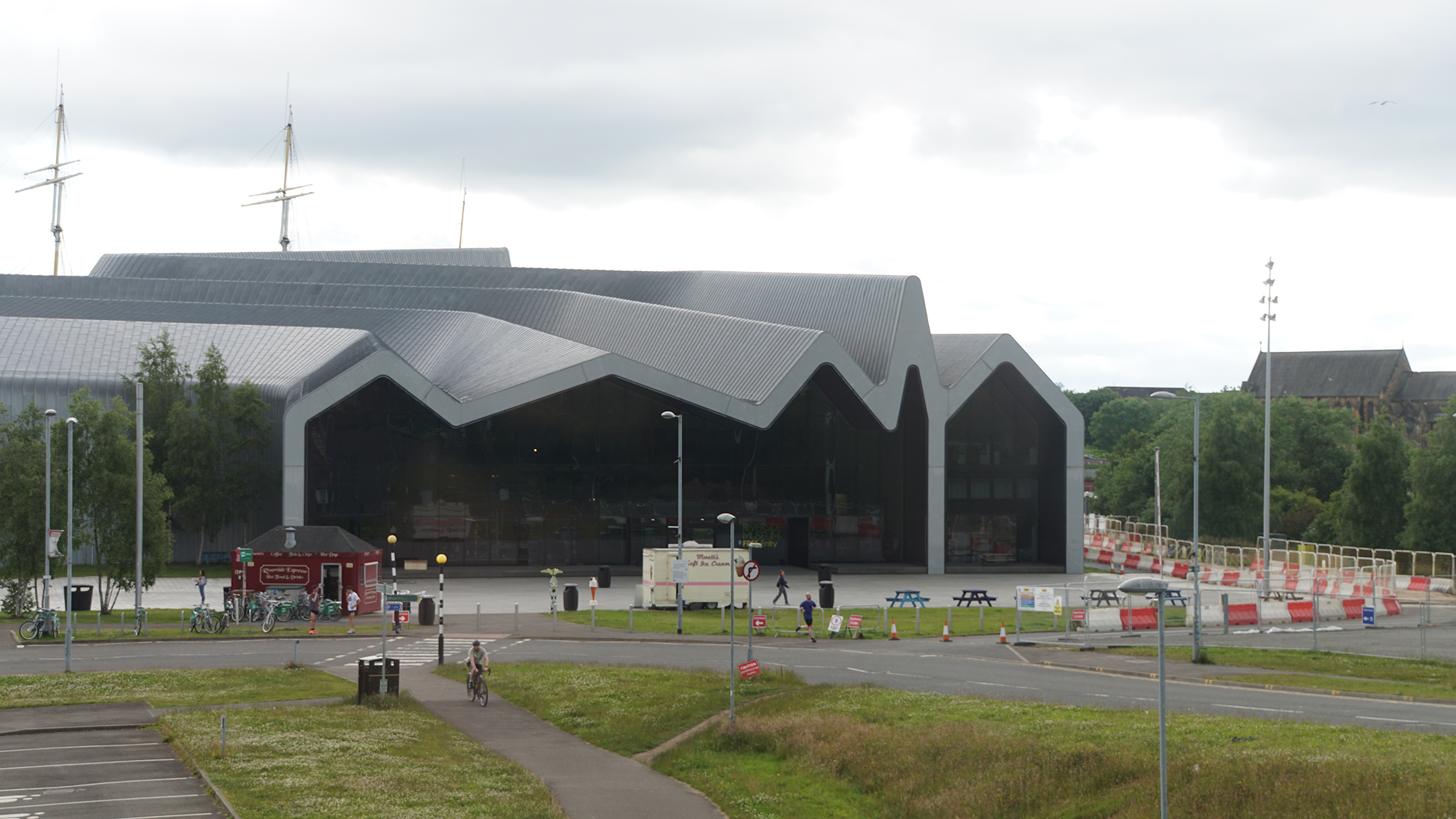 Modern glass and metal panel building with undulating roof