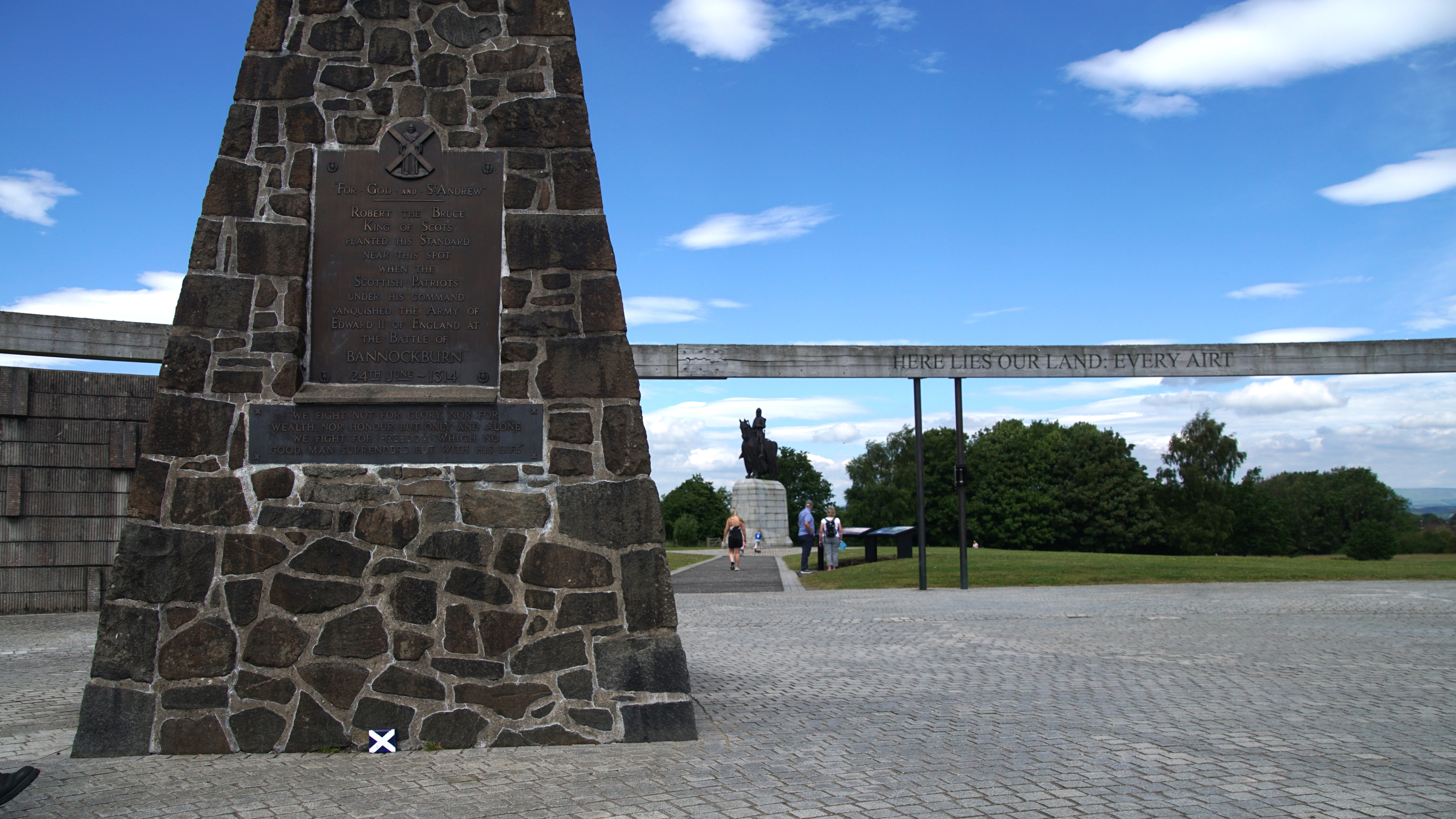 A momument inside a ring with a statue of a man on a hourse in the distance