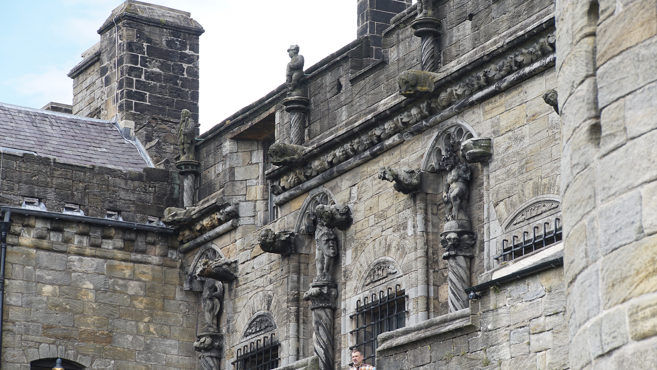 Carvings of people, faces, and animals on a stone wall