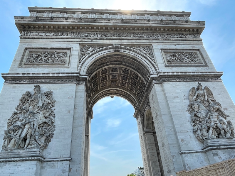 A large stone arch with ornate carvings extends high into the sky