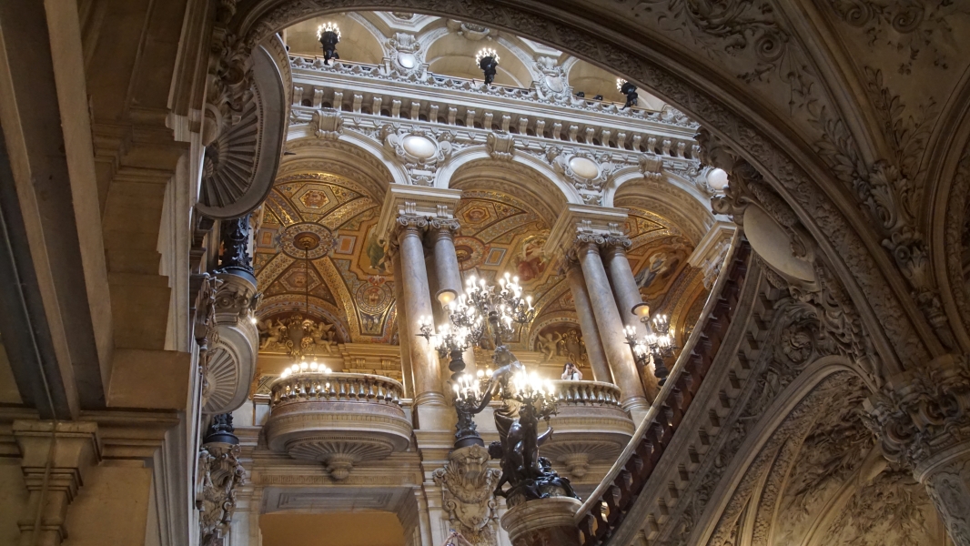 Ornate stone archways display increasing amounts of light and color moving higher in an atrium