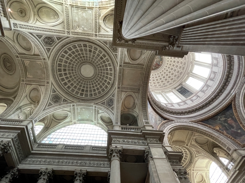 Coffered domes and arches high allow light into the interior of white stone building