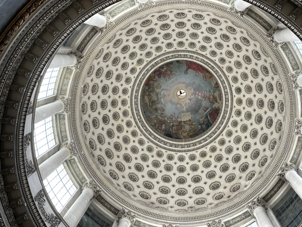 A painting at the top of a coffered dome with windows