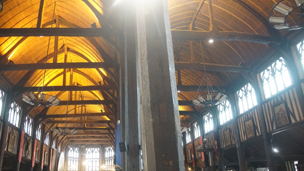 Two arched ceilings extend parallel to each other with wood staves reminiscent of the hulls of sailing ships