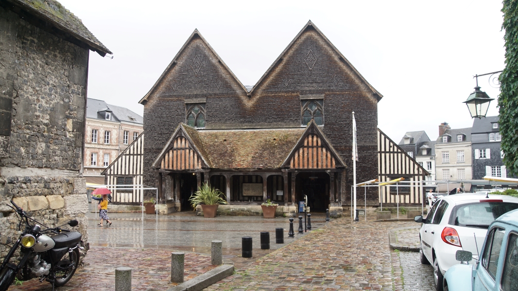A simple slate covered façade with two triangular peaks and half-timber additions on each side