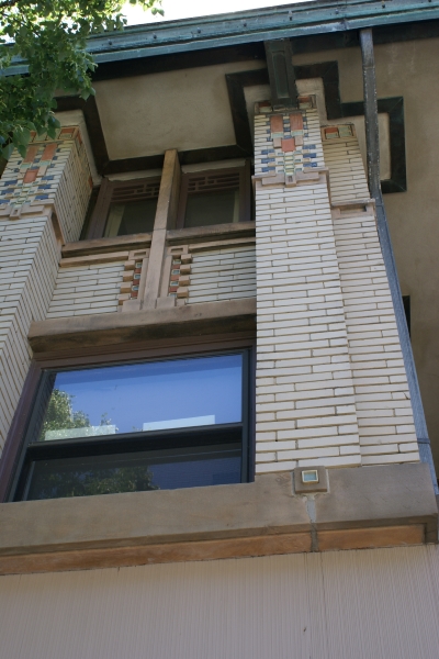 Yellow brick with patterns of protuding bricks and color elements 