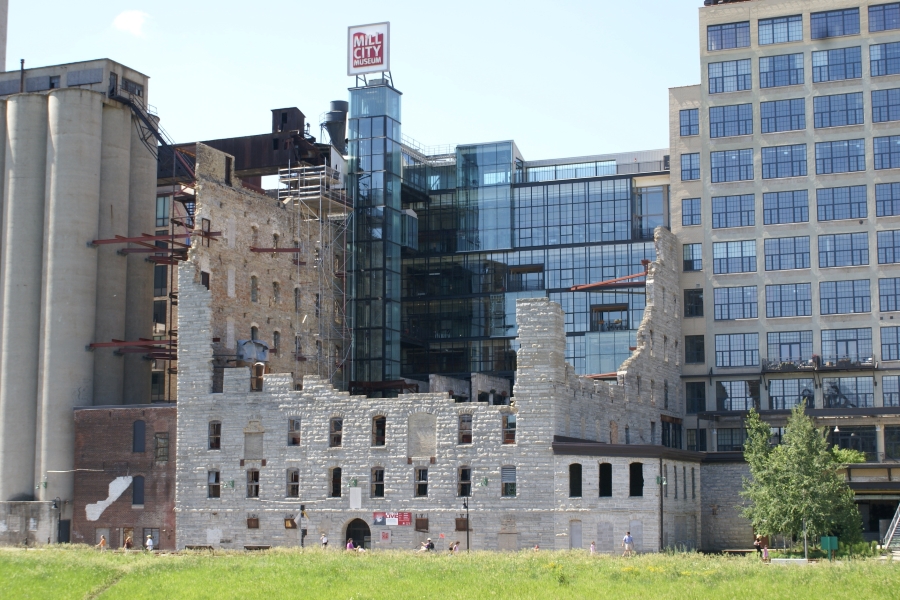 Jagged opped stone walls stand among modern glass buildings