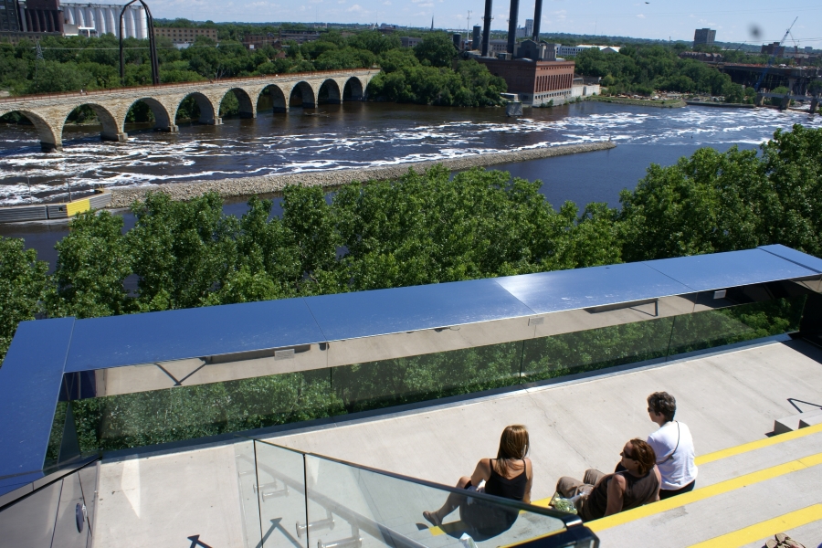 The river rolls by as viewed from the elevated patio with glass railings