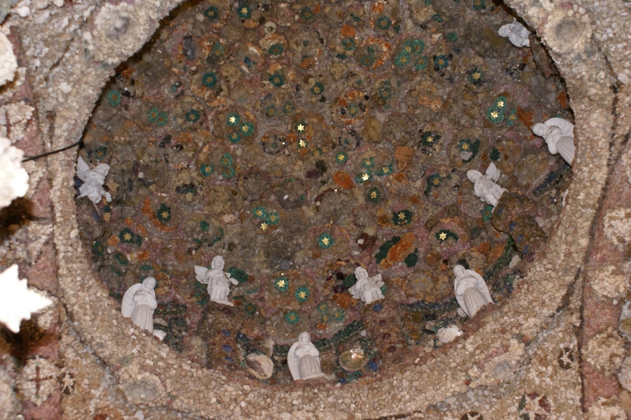 A dome above sparkles with geodes with small white angel statues around the rim