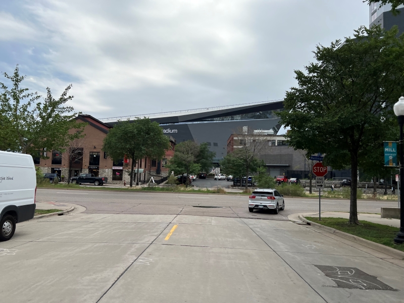 A large sloped topped building looms over two story brick structures in the foreground