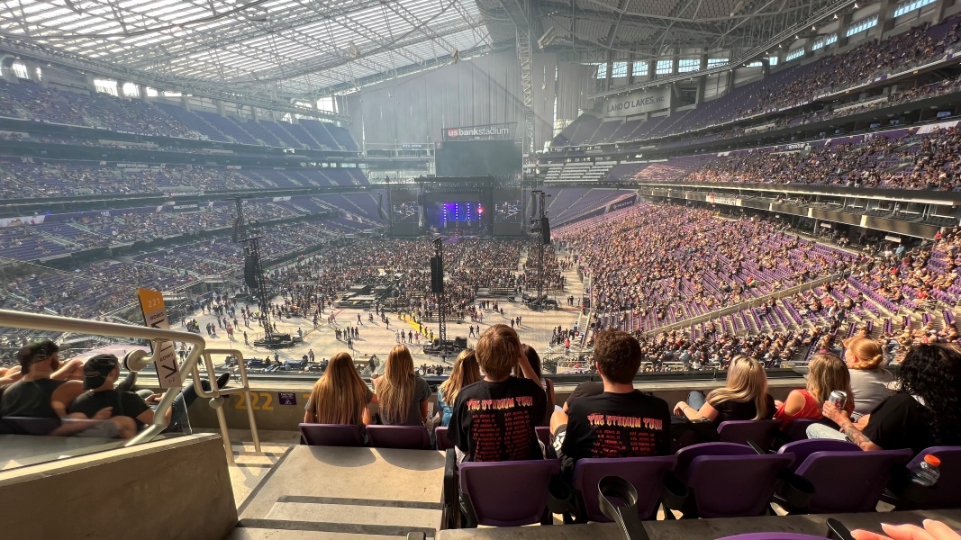 People fill in their seats for inside a large stadium with a partially transparent roof