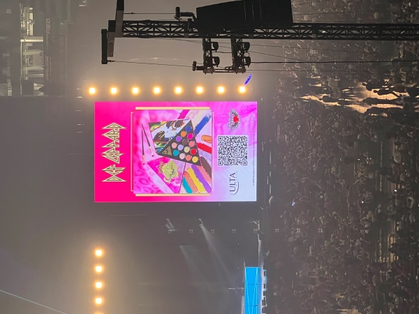 An advertisement showing a triangle shaped box with makeup in colors matching an album cover