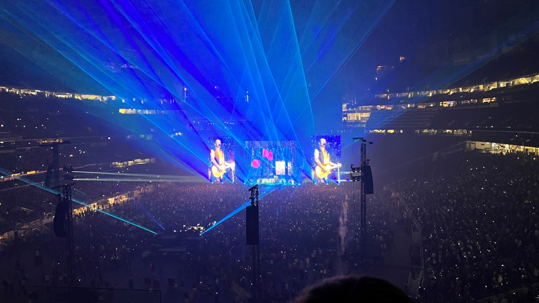 The stage is lit up by lasers as Def Leppard’s guitarist is shown on the displays
