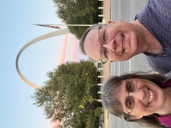 James and Julie pose for a selfie with the St. Louis Arch set against the purple sky of sunset