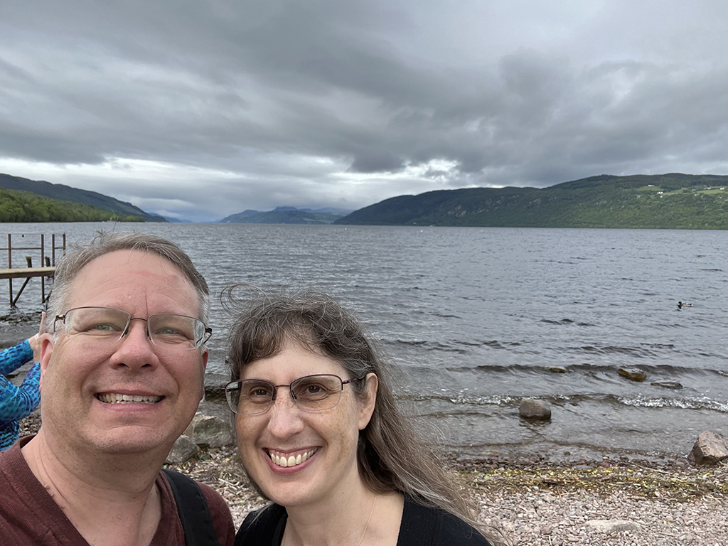 James and Julie in front of a loch in Scotland